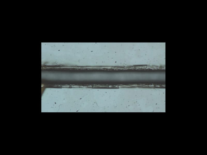 Полученное с помощью оптического микроскопа изображение разреза на защитной пленке (ПЭТ) 3M™, выполненного лазером с длиной волны 9,3 мкм